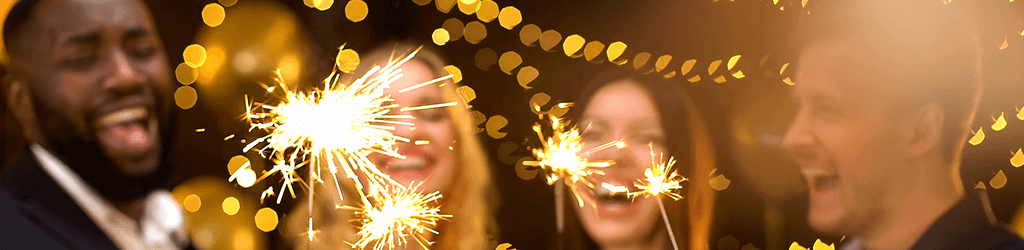 2 men and 2 women celebrating new years eve with sparklers
